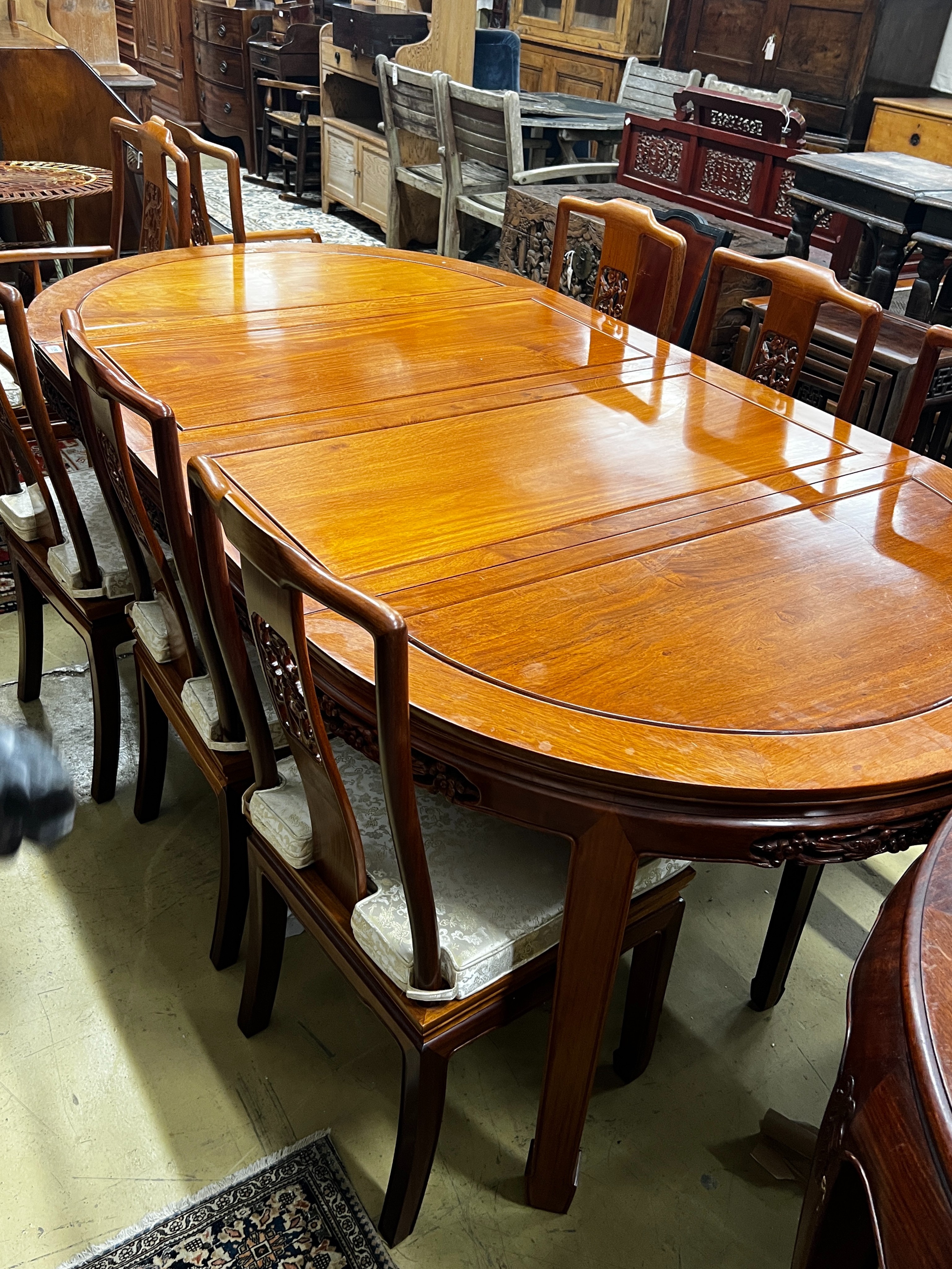 A Chinese hardwood extending dining table, length 214cm, width 111cm, height 77cm extended, two spare leaves together with eight chairs (2 with arms)